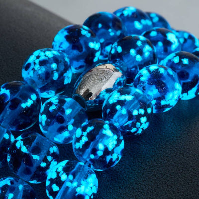NOGU blue translucent glass bead bracelet with vivid turquoise speckles and a polished silver-tone signature bead.