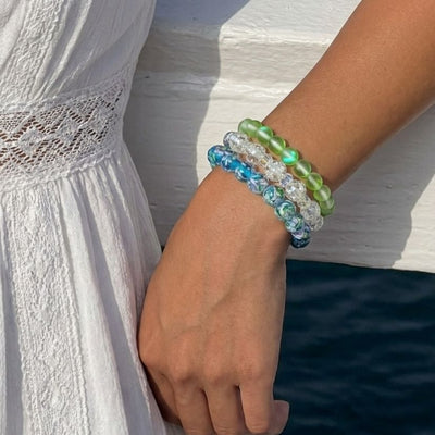 NOGU Whiteout Snow Globe crystal bead bracelets stacked with luminous aqua, clear and frosted green styles.