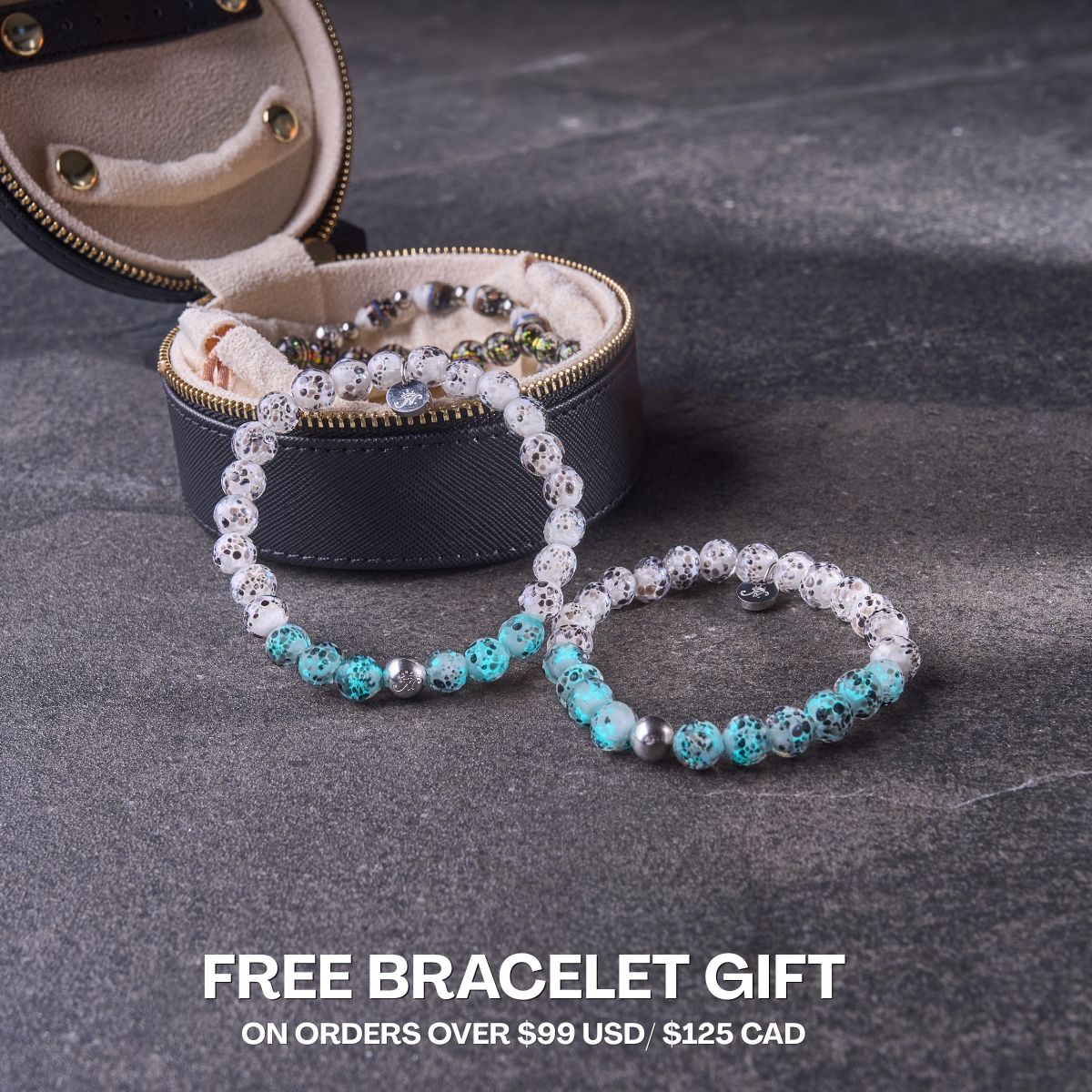 Turquoise and white speckled beaded bracelets with silver-tone accents displayed beside an open black travel jewelry case.