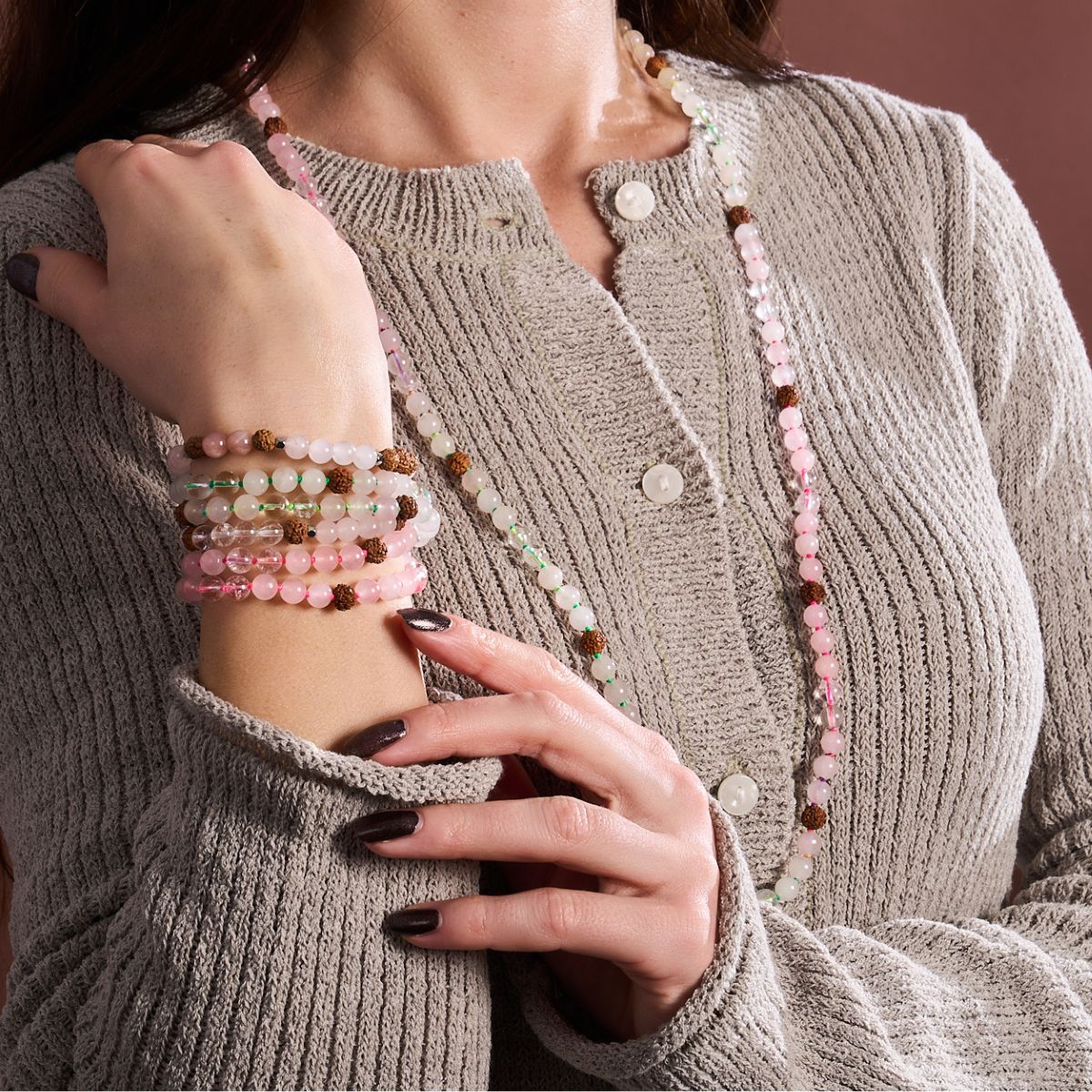 Layered pink and white beaded bracelets with textured brown accent beads, paired with a matching long beaded necklace.