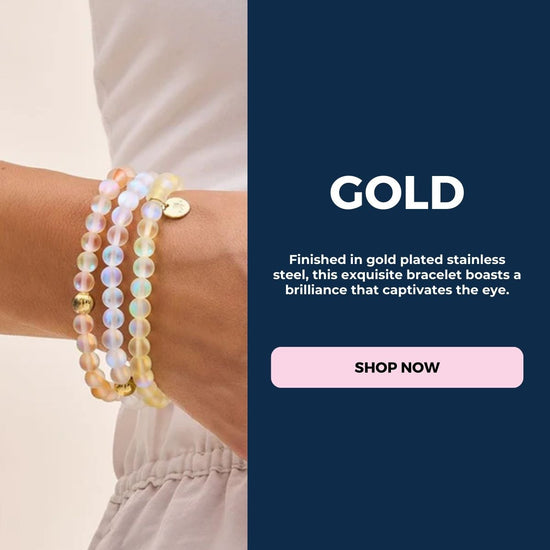 NOGU gold-plated stainless steel bracelet with iridescent translucent beads, layered on the wrist.