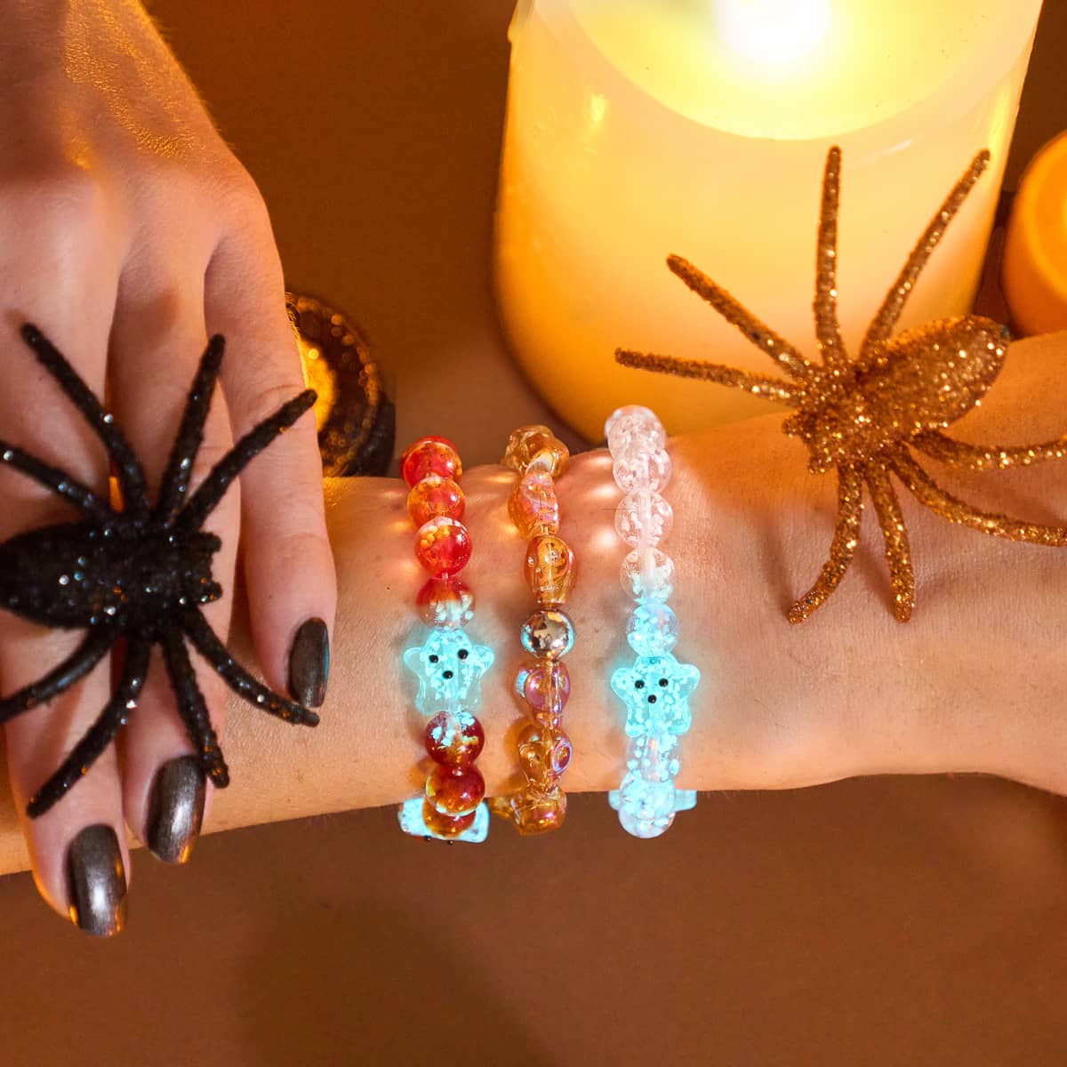 Arm with three bracelets including Berry Boo Silver Firefly Glass Ghost with glowing blue ghost beads and orange lampwork beads by NOGU