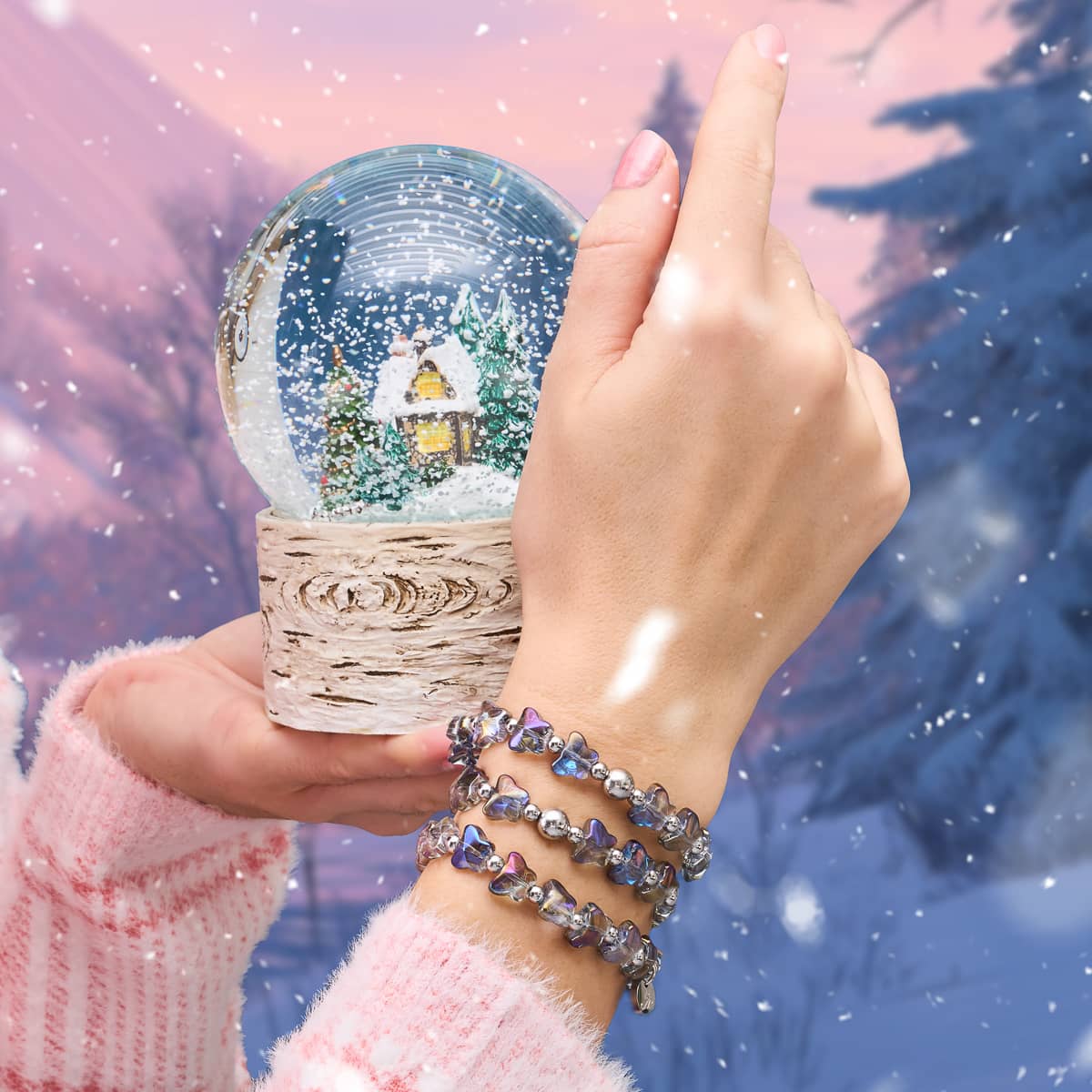 Unicorn Blue butterfly stretch bracelets with silver beads worn on wrist holding a snow globe with winter scene by NOGU