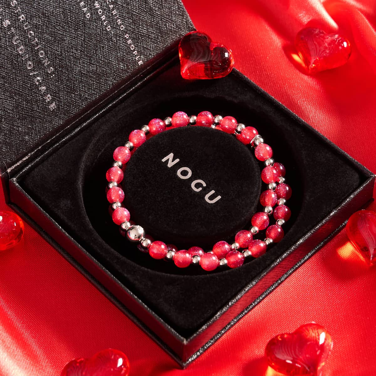 Fresh Strawberry Dreamscape Opal Wrap with red iridescent beads and silver stainless steel beads in black velvet NOGU box on red fabric