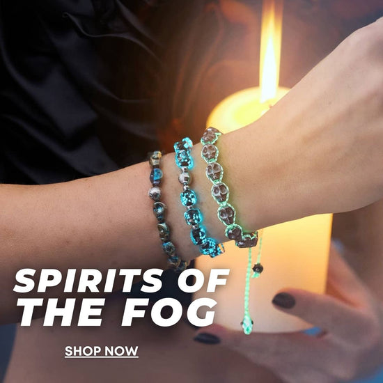 NOGU Spirits of the Fog bracelets in reflective blue and silver beads layered on a wrist against candlelight.