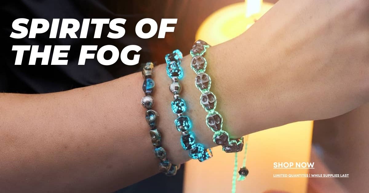 Two wrists wearing translucent blue and smoky gray beaded bracelets from NOGU’s Spirits of the Fog collection.