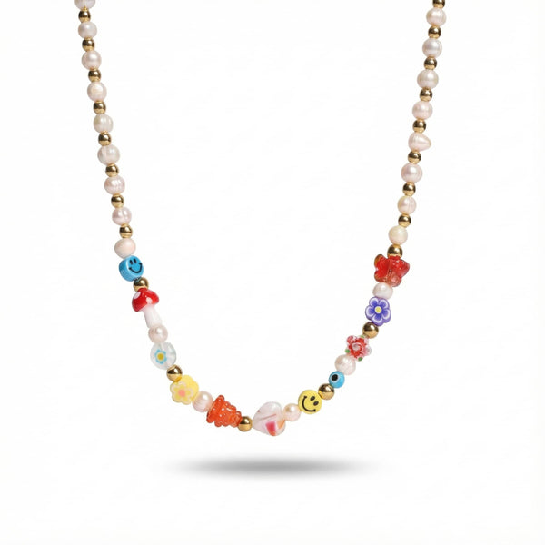 Gold-tone stainless steel necklace with freshwater pearls, gold beads, and colorful rainbow charms including flowers and smiley faces.