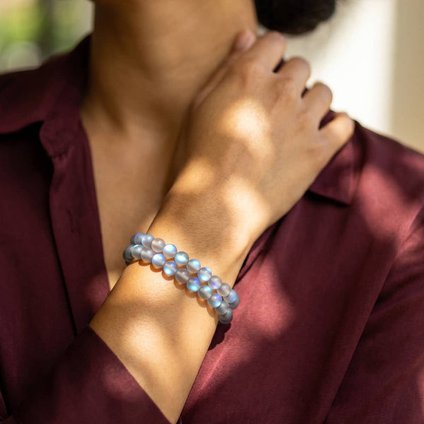 Grey and silver Mermaid Glass bead bracelet with iridescent blue-lilac round beads, worn stacked on a wrist.