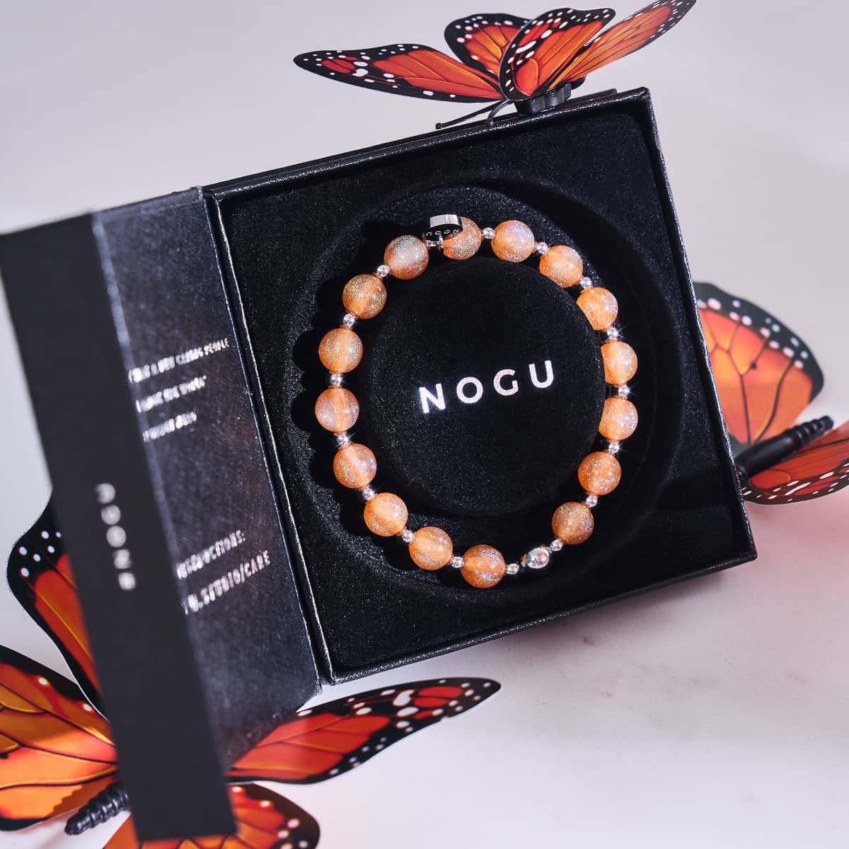 A stack of glowing bracelets on a woman's wrist, perfect for a chic Halloween look.