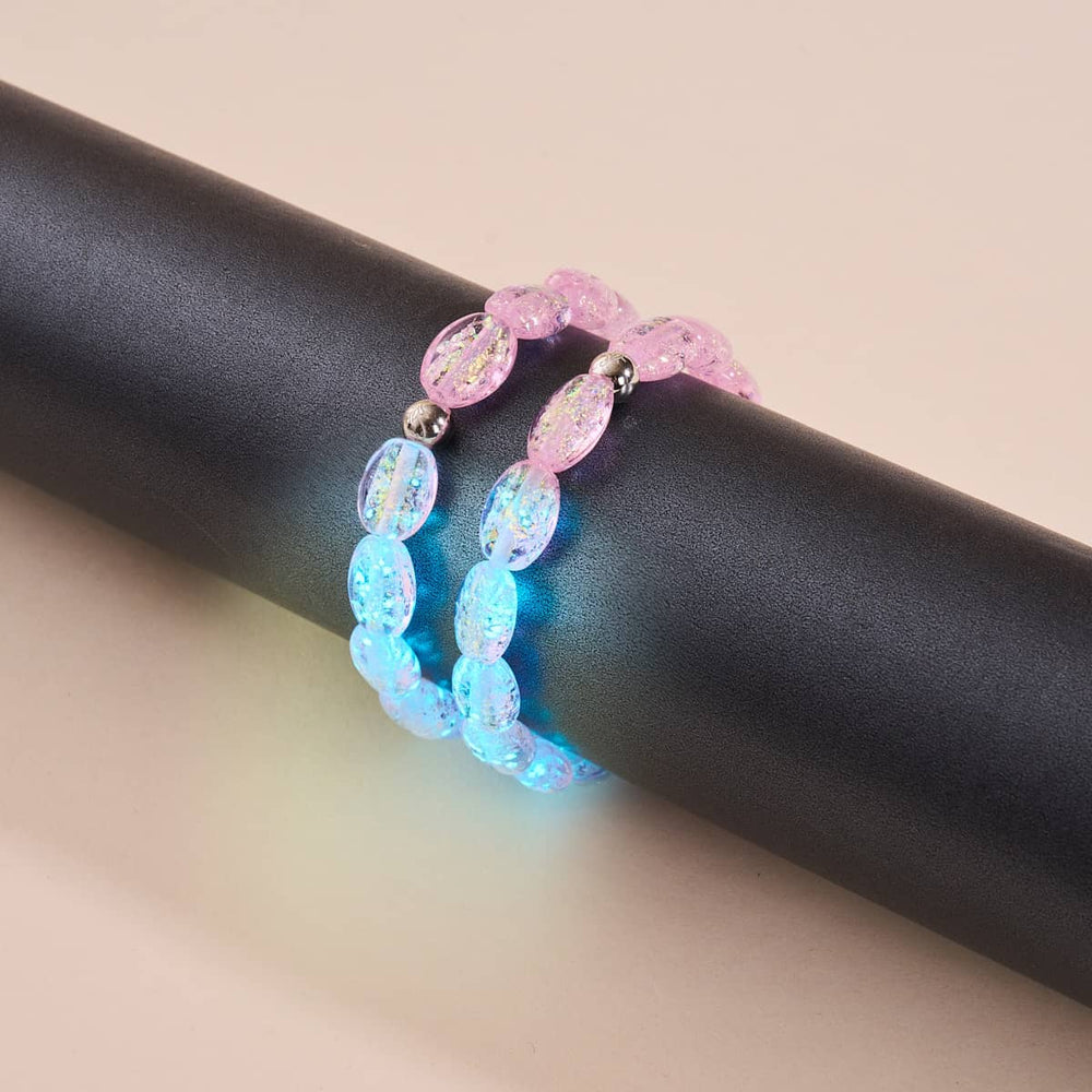 Pink Pony Club bracelets with iridescent pink and blue Firework Glass pebbles and sterling silver beads on black display rod by NOGU