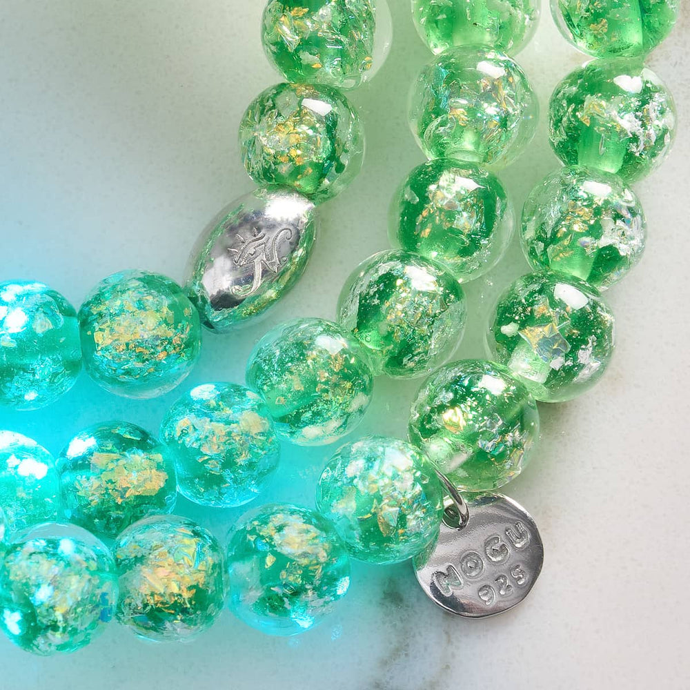Verdant Burst close-up of green and gold Firework Glass beads with .925 sterling silver charm and clasp by NOGU