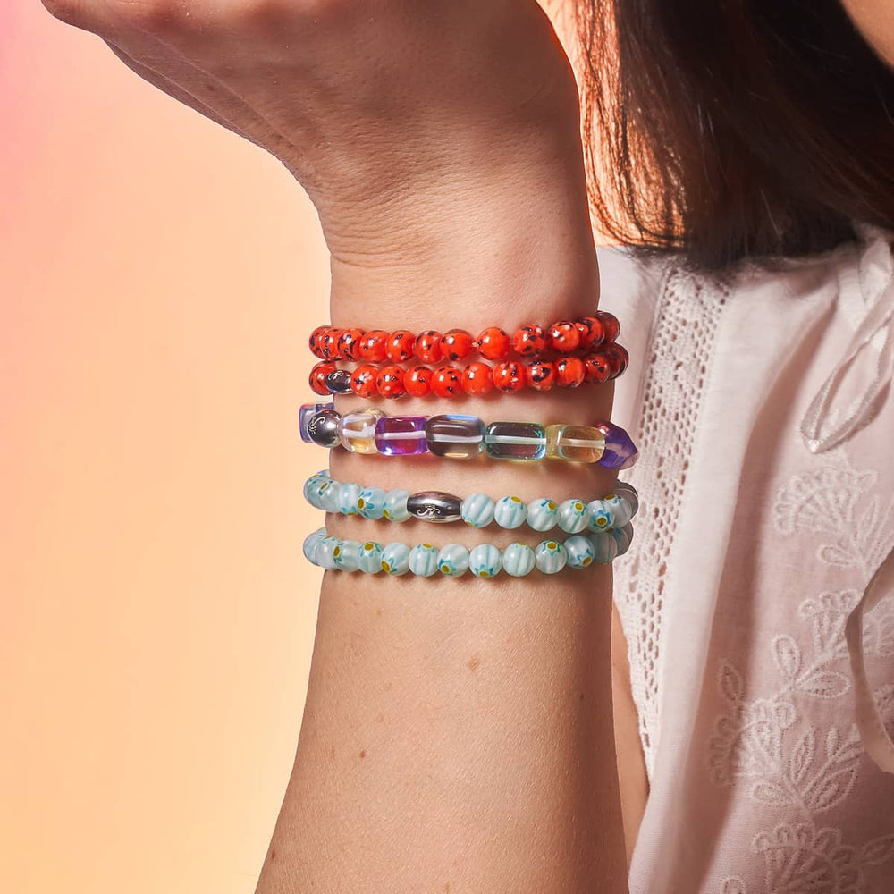 Cosmic Cascade Galaxy Glass bracelet with rectangular beads and sterling silver logo bead on wrist by NOGU