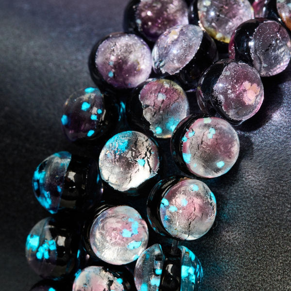 Close-up of Pink Moon Lunar Glass beads showing pink, silver, and glowing blue details by NOGU